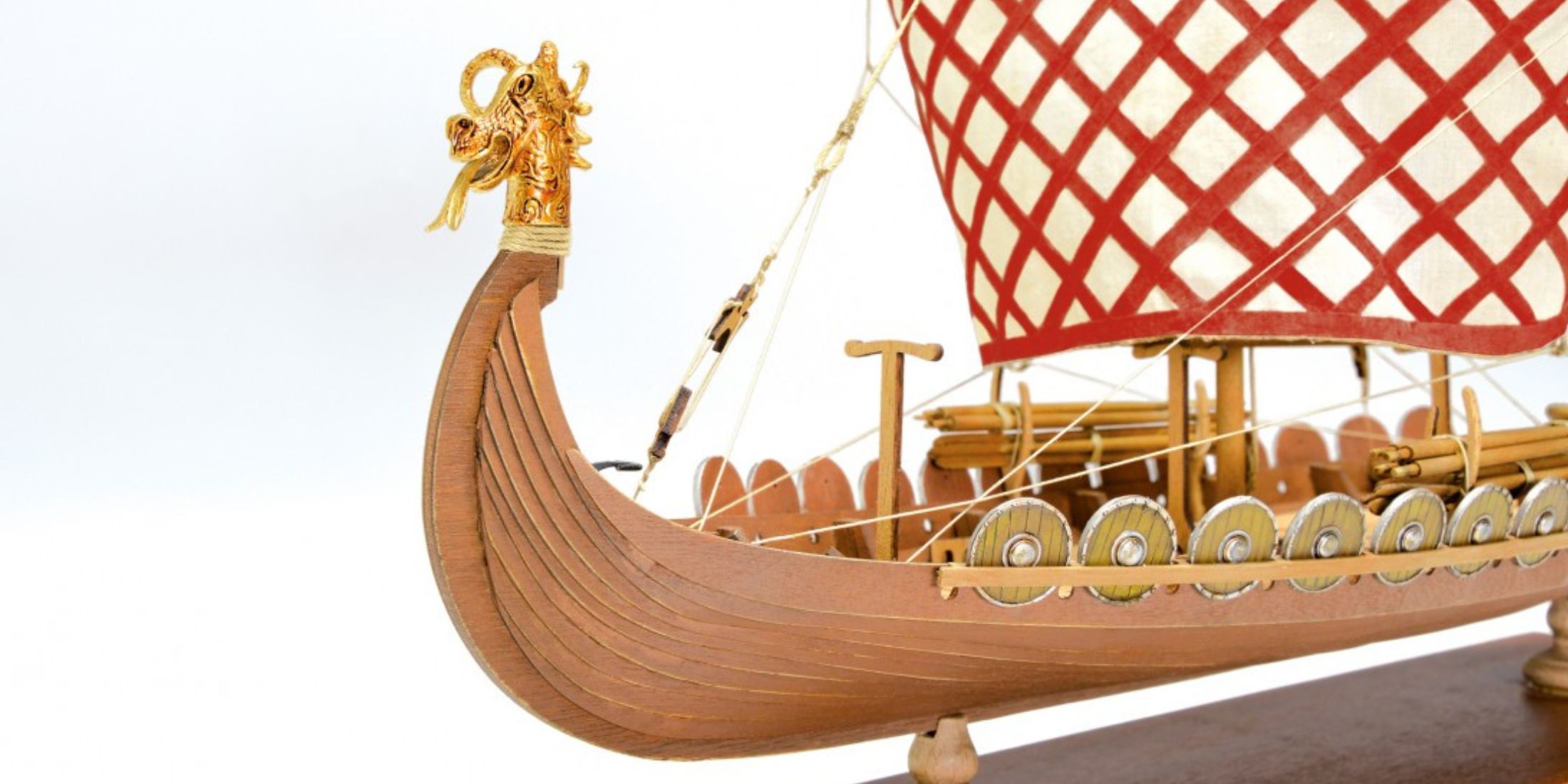 Detail of wooden Viking drakkar with decorated sail and carved prow