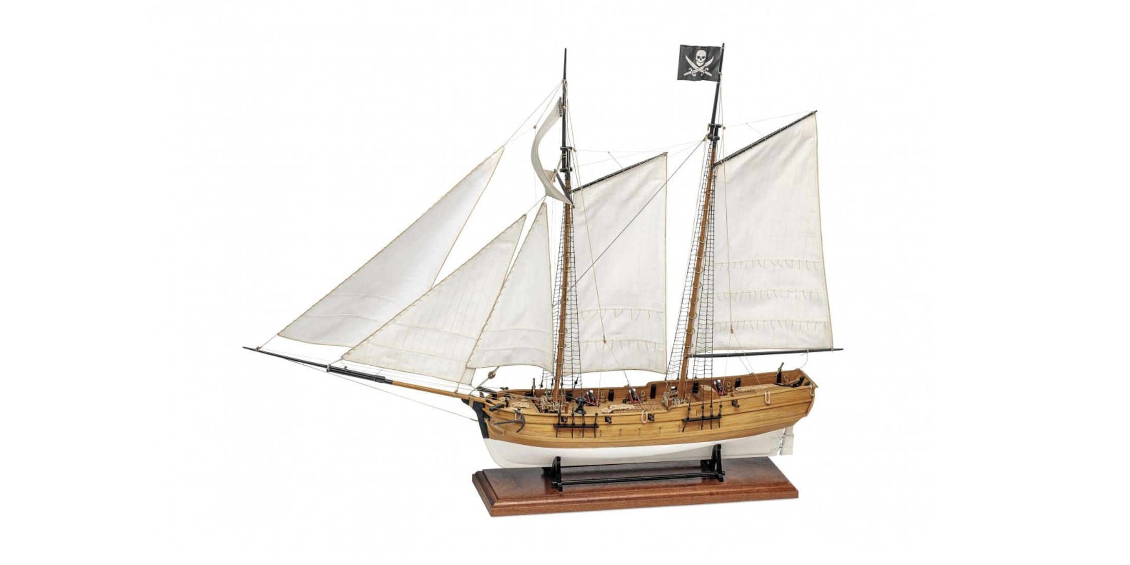 Scale model of pirate ship "Adventure" featuring Jolly Roger flag and white sails. Assembly kit for naval modeling enthusiasts.